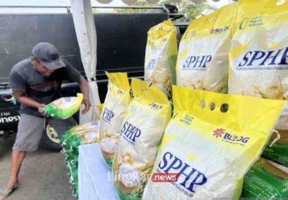 Seseorang menyusun karungan beras SPHP kemasan 5 kg